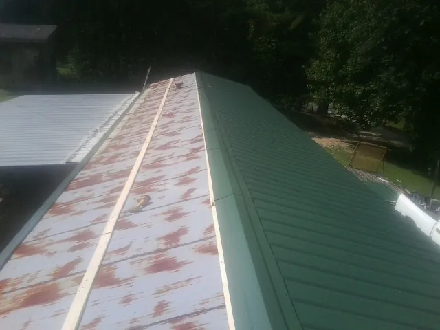 Old rusted panels beside newly installed green metal roofing — Wind Damage Roof Repair by Roofing Brothers in Palos Verdes Peninsula