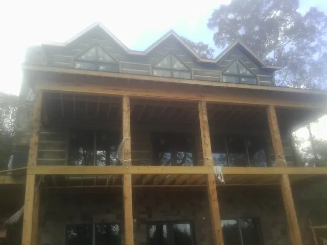 Dormers and porch framing on a large log home under construction — Roof Coating work by our crew in Palos Verdes Peninsula